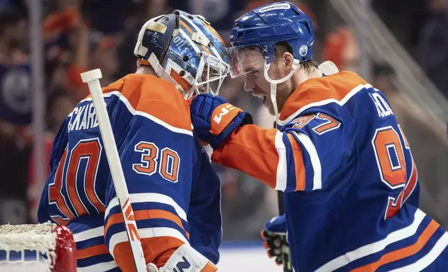 Edmonton Oilers goalie Calvin Pickard (30) and Connor McDavid (97) celebrate the win over the Los Angeles Kings in NHL playoff action in Edmonton, Alberta, Friday, April 25, 2025. (Jason Franson/The Canadian Press via AP)