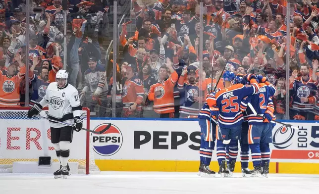 Los Angeles Kings' Anze Kopitar (11) skates past as the Edmonton Oilers celebrate after a goal during the first period of Game 3 of a first-round NHL hockey playoff series in Edmonton, Alberta, Friday, April 25, 2025. (Jason Franson/The Canadian Press via AP)