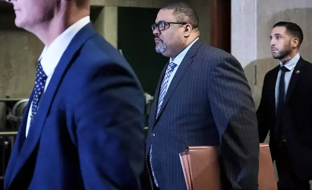 Manhattan district attorney Alvin Bragg, center, walks through Manhattan criminal court on the day of Harvey Weinstein's retrial, Tuesday, April 22, 2025, in New York. (AP Photo/Julia Demaree Nikhinson)