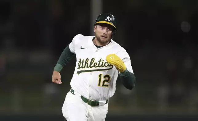 Athletics Max Schuemann (12) is about to round third and scores on a single by Athletics Luis Urías (not pictured) against the Texas Rangers during the ninth inning of a baseball game Thursday, April 24, 2025, in West Sacramento, Calif. (AP Photo/Scott Marshall)