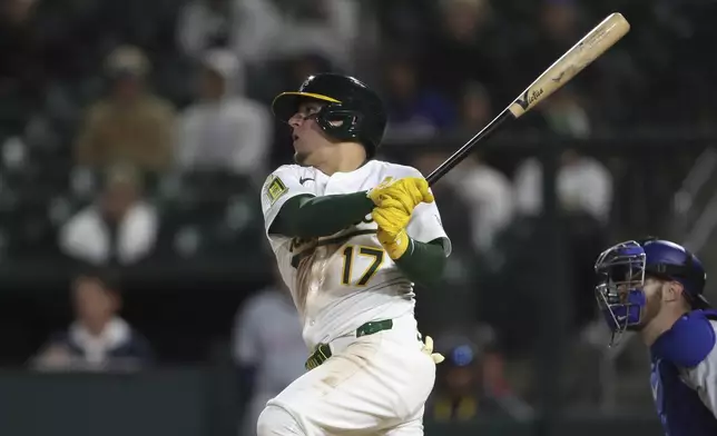 Athletics Luis Urías (17) hits a single that scores the game tying run against the Texas Rangers during the ninth inning of a baseball game Thursday, April 24, 2025, in West Sacramento, Calif. (AP Photo/Scott Marshall)