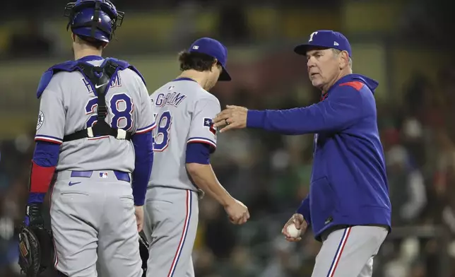 Texas Rangers manager Bruce Bochy, right, takes the ball from pitcher Jacob deGrom, middle, during the sixth inning of a baseball game Thursday, April 24, 2025, in West Sacramento, Calif. (AP Photo/Scott Marshall)