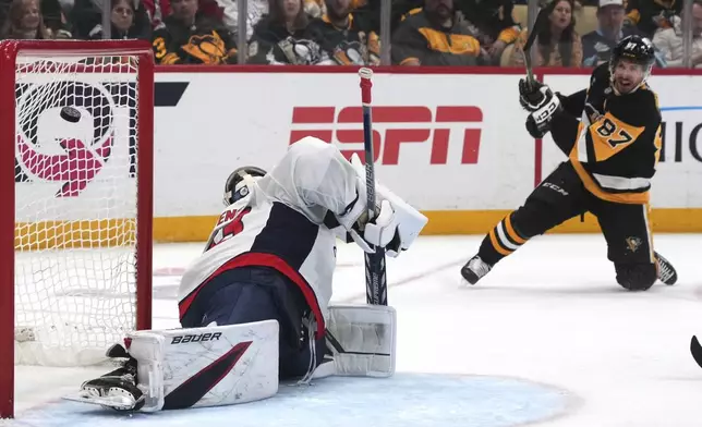 Pittsburgh Penguins' Sidney Crosby (87) get a shot past Washington Capitals goaltender Clay Stevenson, left, for a goal during the second period of an NHL hockey game in Pittsburgh, Thursday, April 17, 2025. (AP Photo/Gene J. Puskar)