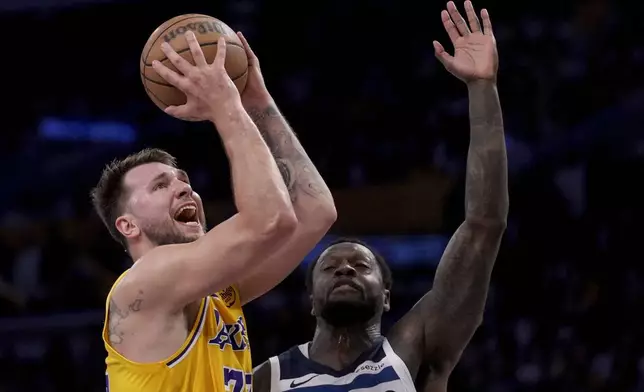 Los Angeles Lakers guard Luka Doncic (77) goes to the basket against Minnesota Timberwolves forward Julius Randle (30) during the first half of Game 2 of an NBA basketball first-round playoff series in Los Angeles, Tuesday, April 22, 2025. (AP Photo/Eric Thayer)