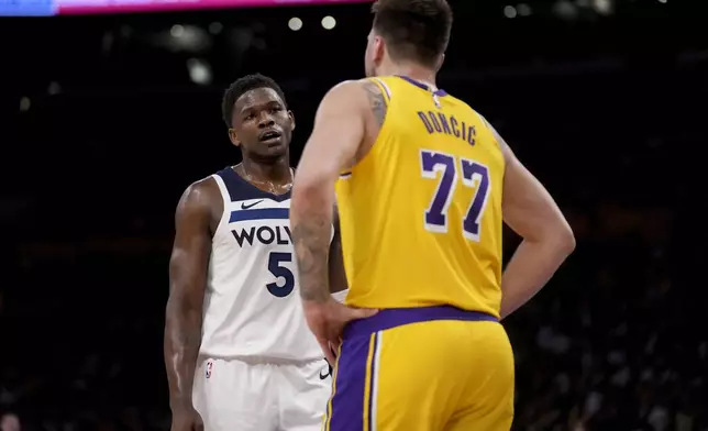 Minnesota Timberwolves guard Anthony Edwards (5) and Los Angeles Lakers guard Luka Doncic (77) interact during the first half of Game 2 of an NBA first-round playoff series in Los Angeles, Tuesday, April 22, 2025. (AP Photo/Eric Thayer)