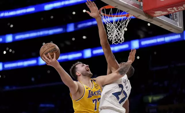 Los Angeles Lakers guard Luka Doncic (77) goes to the basket against Minnesota Timberwolves center Rudy Gobert (27) during the first half of Game 2 of an NBA first-round playoff series in Los Angeles, Tuesday, April 22, 2025. (AP Photo/Eric Thayer)