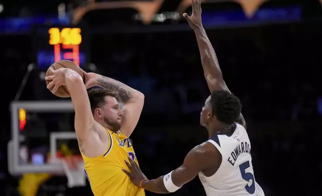 Los Angeles Lakers guard Luka Doncic (77) looks to pass around Minnesota Timberwolves guard Anthony Edwards (5) during the first half of Game 2 of an NBA basketball first-round playoff series in Los Angeles, Tuesday, April 22, 2025. (AP Photo/Eric Thayer)