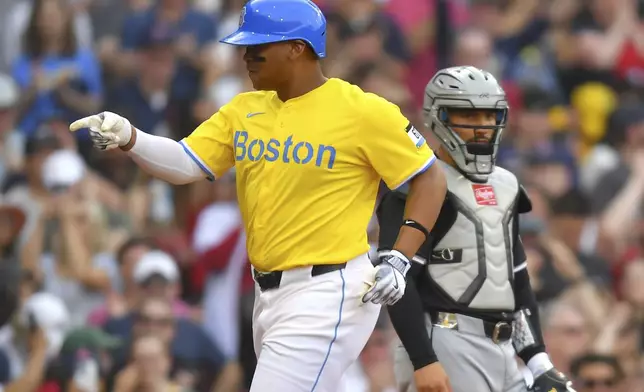 Boston Red Sox's Rafael Devers, left, celebrates as he scores on his three-run home run in front of Chicago White Sox catcher Edgar Quero, right, in the fifth inning of a baseball game, Saturday, April 19, 2025, in Boston. (AP Photo/Steven Senne)