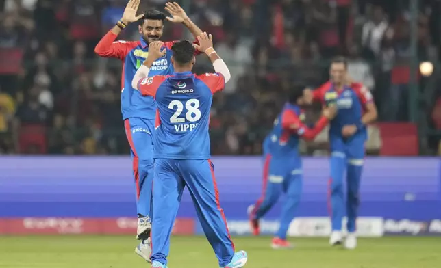 Delhi Capitals' Vipraj Nigam (28) celebrates with captain Axar Patel after the dismissal of Royal Challengers Bengaluru's Virat Kohli during the Indian Premier League cricket match between Royal Challengers Bengaluru and Delhi Capitals at Chinnaswamy Stadium in Bengaluru, India, Thursday, April 10, 2025. (AP Photo/Aijaz Rahi)