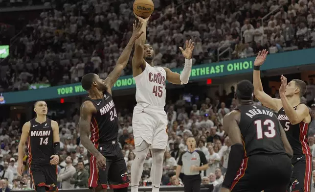 Cleveland Cavaliers guard Donovan Mitchell (45) shoots between Miami Heat's Tyler Herro (14), Haywood Highsmith (24), Bam Adebayo (13) and Nikola Jovic (5) in the second half in Game 2 of an NBA first-round playoff series, Wednesday, April 23, 2025, in Cleveland. (AP Photo/Sue Ogrocki)