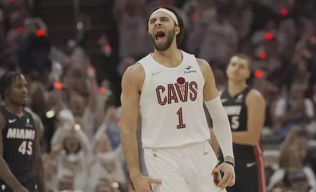 Cleveland Cavaliers guard Max Strus (1) shouts in front of Miami Heat guard Davion Mitchell (45) and forward Nikola Jovic (5) after hitting a three-point basket in the first half in Game 2 of an NBA first-round playoff series, Wednesday, April 23, 2025, in Cleveland. (AP Photo/Sue Ogrocki)