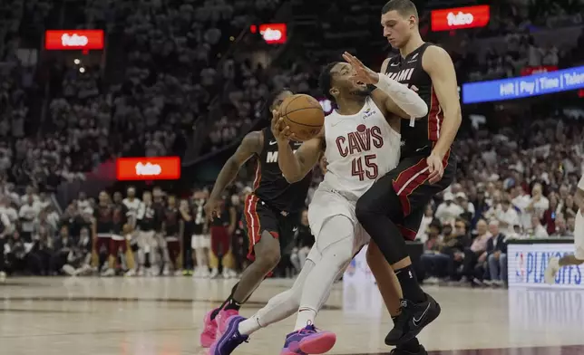 Cleveland Cavaliers guard Donovan Mitchell (45) drives against Miami Heat forward Nikola Jovic, right, in the second half in Game 2 of an NBA first-round playoff series, Wednesday, April 23, 2025, in Cleveland. (AP Photo/Sue Ogrocki)