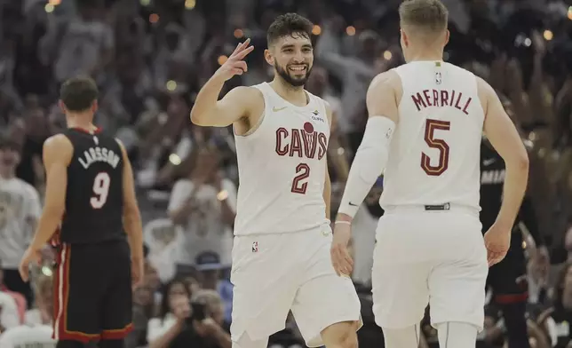 Cleveland Cavaliers guard Ty Jerome (2) congratulates teammate Sam Merrill (5) after Merrill hit a three point basket in the first half in Game 2 of an NBA first-round playoff series, Wednesday, April 23, 2025, in Cleveland. (AP Photo/Sue Ogrocki)