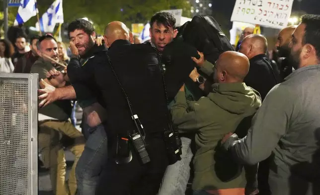 Israeli police push back people protesting against Prime Minister Benjamin Netanyahu's government outside the Knesset, Israel's parliament in Jerusalem, Monday, March 31, 2025. (AP Photo/Ohad Zwigenberg)