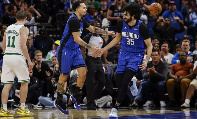 Orlando Magic center Goga Bitadze (35) and guard Cole Anthony, left, celebrate after basket while playing the Boston Celtics during the first half of an NBA basketball game, Wednesday, April 9, 2025, in Orlando, Fla. (AP Photo/Kevin Kolczynski)