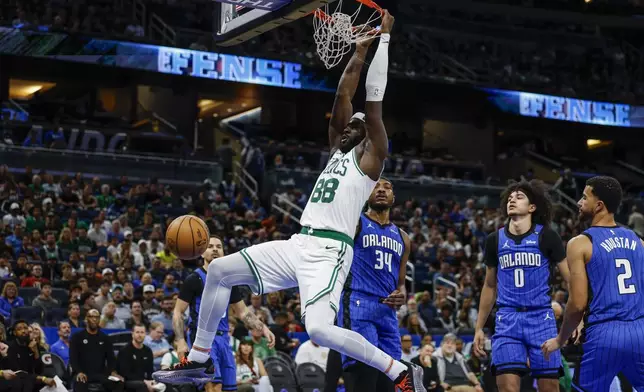Boston Celtics center Neemias Queta (88) dunks the ball over Orlando Magic players during the first half of an NBA basketball game, Wednesday, April 9, 2025, in Orlando, Fla. (AP Photo/Kevin Kolczynski)