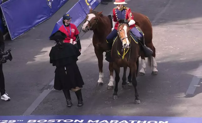 An actor portraying Paul Revere tries to pull his horse, which refused to advance over the line, during a ceremony for the Patriot's Day holiday at the finish prior to the Boston Marathon, Monday, April 21, 2025, in Boston. (AP Photo/Charles Krupa)