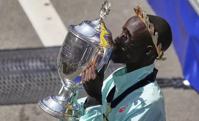 Boston Marathon winner John Korir, of Kenya, kisses the trophy while celebrating after the race, Monday, April 21, 2025, in Boston. (AP Photo/Charles Krupa)