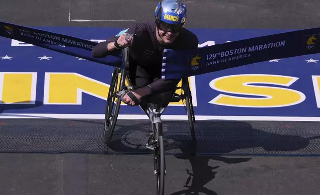 Marcel Hug, of Switzerland, breaks the tape to win the men's wheelchair division during the Boston Marathon, Monday, April 21, 2025, in Boston. (AP Photo/Charles Krupa)