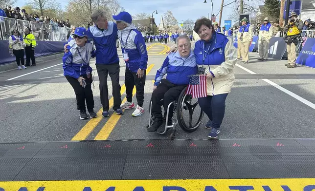 Four-time Boston Marathon winner Bill Rodgers and wheelchair athlete pioneer Bob Hall greet race volunteers at the start of the Boston Marathon Monday April 21, 2025. They are the grand marshals of the 129th Boston Marathon. (AP Photo/ Jennifer McDermott)