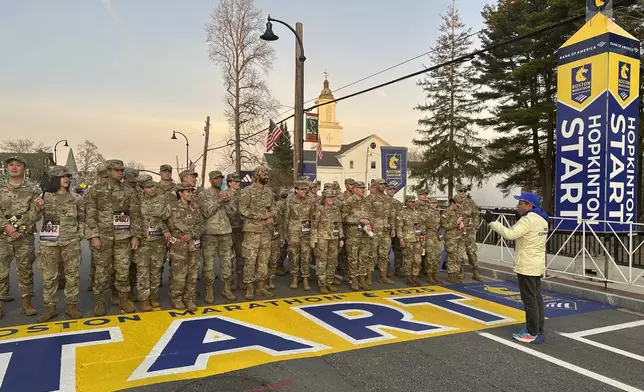 Boston Marathon Race Director Dave McGillivray, right, sends a group of Massachusetts National Guard members across the start line, launching the 129th edition of the race, in Hopkinton, Mass, early Monday, April 21, 2025. (AP Photo/Jennifer McDermott)