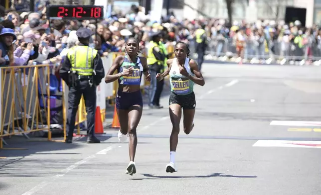At the Boston Marathon Monday, April 21, 2025, Sharon Lokedi, left, outruns two-time Boston Marathon defending champion Hellen Obiri over the final mile of the course. Lokedi won and broke the Boston Marathon course record. (AP Photo/ Jennifer McDermott)