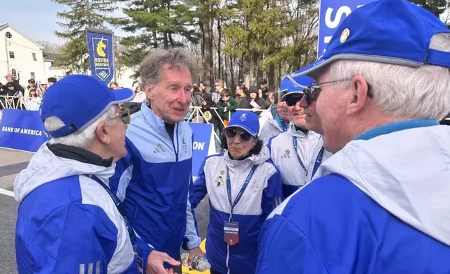 Four-time Boston Marathon winner Bill Rodgers and wheelchair athlete pioneer Bob Hall greet race volunteers at the start of the Boston Marathon Monday, April 21, 2025. They are the grand marshals of the 129th Boston Marathon. (AP Photo/ Jennifer McDermott)