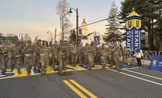 Boston Marathon Race Director Dave McGillivray, right, sends a group of Massachusetts National Guard members across the start line, launching the 129th edition of the race, in Hopkinton, Mass, early Monday, April 21, 2025. (AP Photo/Jennifer McDermott)