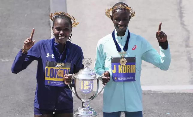 Boston Marathon winner John Korir, of Kenya, right, and women's division winner Sharon Lokedi, of Kenya, celebrate after the race, Monday, April 21, 2025, in Boston. (AP Photo/Charles Krupa)