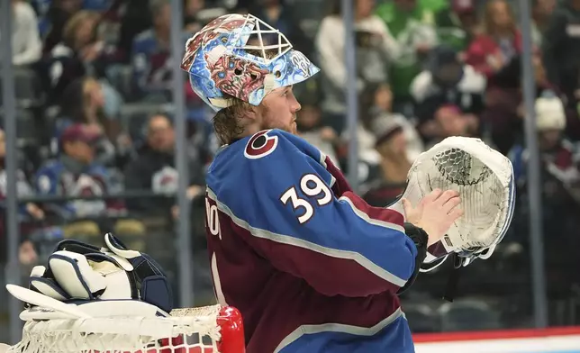 Colorado Avalanche goaltender Mackenzie Blackwood pulls on a glove before the second period of an NHL hockey game against the Vancouver Canucks, Thursday, April 10, 2025, in Denver. (AP Photo/David Zalubowski)