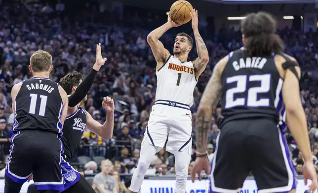 Denver Nuggets forward Michael Porter Jr. (1) goes up for a shot as Sacramento Kings forward Doug McDermott, left center, defends during the first half of an NBA basketball game Wednesday, April 9, 2025, in Sacramento, Calif. (AP Photo/Sara Nevis)