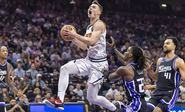 Denver Nuggets guard Christian Braun, center, makes a layup past Sacramento Kings guard Keon Ellis (23) during the first half of an NBA basketball game Wednesday, April 9, 2025, in Sacramento, Calif. (AP Photo/Sara Nevis)