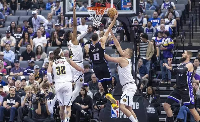 Sacramento Kings guard Zach LaVine (8) goes up for a layup as Denver Nuggets forward Peyton Watson (8) defends during the first half of an NBA basketball game Wednesday, April 9, 2025, in Sacramento, Calif. (AP Photo/Sara Nevis)