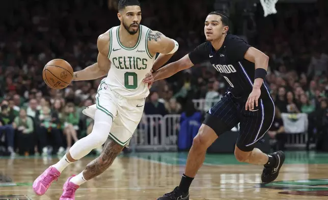 Boston Celtics' Jayson Tatum, left, drives past Orlando Magic's Anthony Black during the first half in game 1 of a first-round NBA playoff basketball series Sunday, April 20, 2025, in Boston. (AP Photo/Michael Dwyer)