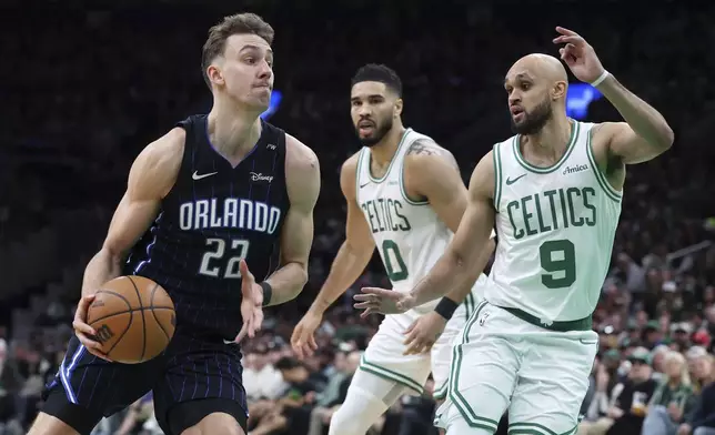 Orlando Magic's Franz Wagner (22) drives past Boston Celtics' Derrick White (9) in front of Jayson Tatum (0) during the second half in Game 1 of a first-round NBA playoff basketball series Sunday, April 20, 2025, in Boston. (AP Photo/Michael Dwyer)