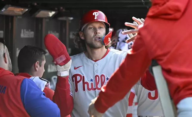 Philadelphia Phillies' Alec Bohm celebrates in the dugout after he scores during the fourth inning of a baseball game against the Chicago Cubs, Saturday, April 26, 2025, in Chicago. (AP Photo/Matt Marton)