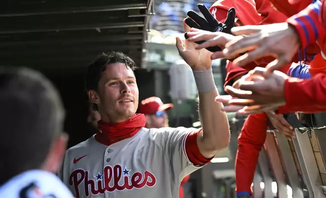 Philadelphia Phillies' Max Kepler celebrates in the dugout after he scored during the fourth inning of a baseball game against the Chicago Cubs, Saturday, April 26, 2025, in Chicago. (AP Photo/Matt Marton)