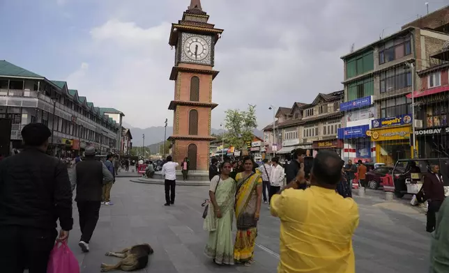 Indian tourists take pictures near a clock tower at city centre in Srinagar, Indian controlled Kashmir,Tuesday, April. 22, 2025. (AP Photo/Mukhtar Khan)