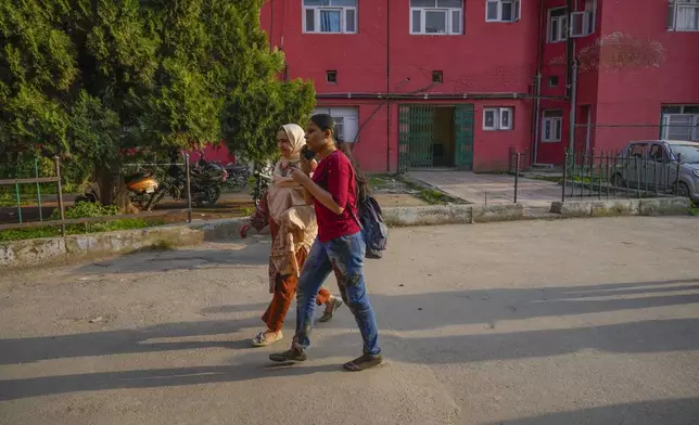 An Indian tourist, right, with blood-soaked trousers speaks on the phone as she arrives at a hospital in Anantnag after assailants indiscriminately fired at tourists visiting Pahalgam, Indian controlled Kashmir, Tuesday, April 22, 2025.(AP Photo/Dar Yasin)