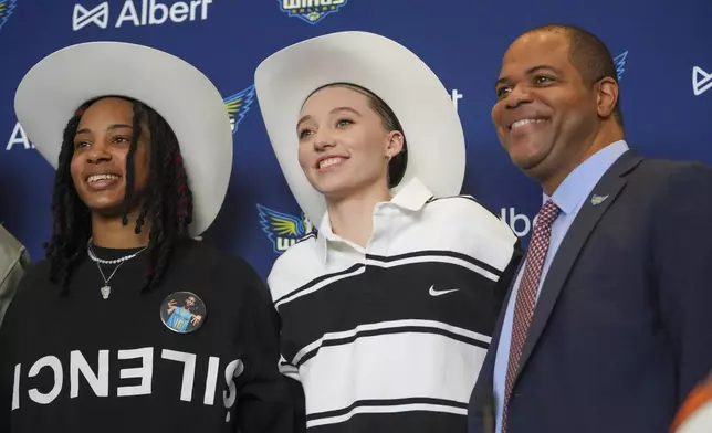 Dallas Wings' Paige Bueckers, center, selected No. 1 overall in the WNBA basketball draft, and Aziaha James, selected No. 12 overall, sport a cowboy hats gifted to them while posing for photographs with Dallas Mayor Eric Johnson during an introductory press conference Wednesday, April 23, 2025, in Dallas. (AP Photo/Julio Cortez)