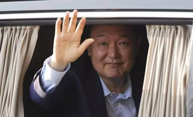 Former South Korean President Yoon Suk Yeol waves upon his arrival at the private residence in Seoul, South Korea, Friday, April 11, 2025. (AP Photo/Lee Jin-man)