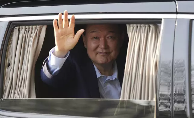 Former South Korean President Yoon Suk Yeol waves upon his arrival at the private residence in Seoul, South Korea, Friday, April 11, 2025. (AP Photo/Lee Jin-man)