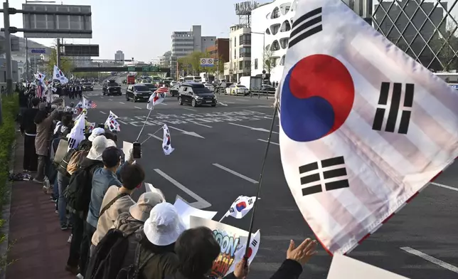 South Korea's ousted president Yoon Suk Yeol waves to supporters from his car as he leaves the official residence in Seoul, South Korea, Friday, April 11, 2025. ( Jung Yeon-je /Pool Photo via AP)