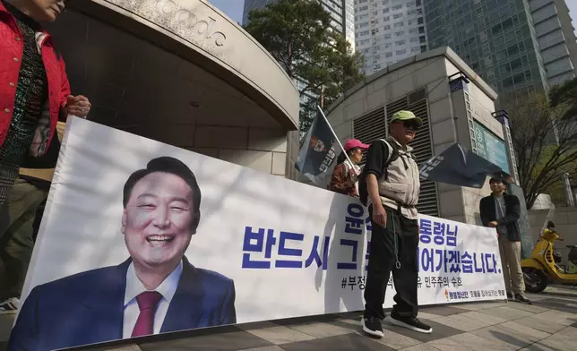 Supporters of recently removed South Korean President Yoon Suk Yeol hold a banner with a picture of Yoon near his private residence in Seoul, South Korea, Friday, April 11, 2025. The part of letters read "President Yoon Suk Yeol." (AP Photo/Lee Jin-man)