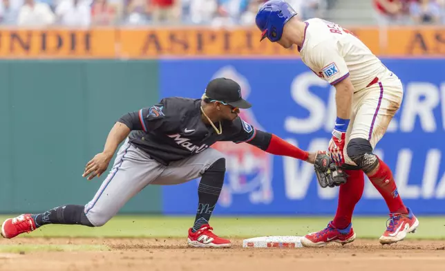 Philadelphia Phillies' J.T. Realmuto is safe at second on a double before Miami Marlins second baseman Otto Lopez can make the tag in the second inning of a baseball game, Saturday, April 19, 2025, in Philadelphia. (AP Photo/Laurence Kesterson)