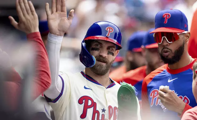 Philadelphia Phillies' Bryce Harper celebrates his run in the third inning of a baseball game against the Miami Marlins, Saturday, April 19, 2025, in Philadelphia. (AP Photo/Laurence Kesterson)