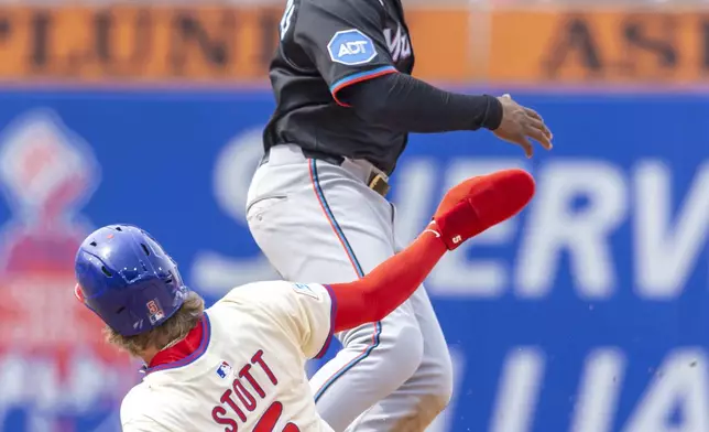 Philadelphia Phillies' Bryson Stott (5) is safe at second before Miami Marlins shortstop Xavier Edwards can make the catch in the fifth inning of a baseball game, Saturday, April 19, 2025, in Philadelphia. (AP Photo/Laurence Kesterson)