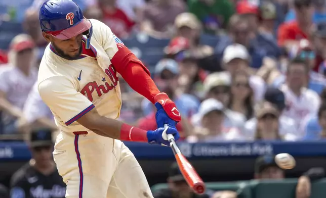 Philadelphia Phillies' Johan Rojas hits an RBI single in the fifth inning of a baseball game against the Miami Marlins, Saturday, April 19, 2025, in Philadelphia. (AP Photo/Laurence Kesterson)