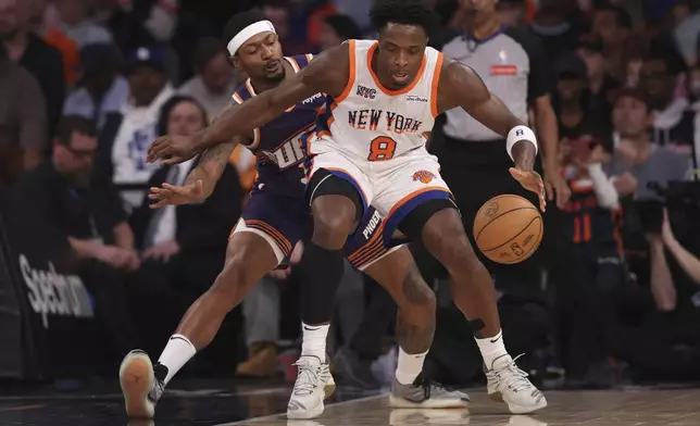 New York Knicks' OG Anunoby (8) dribbles against Phoenix Suns' Bradley Beal, left, during the first half of an NBA basketball game Sunday, April 6, 2025, in New York. (AP Photo/Pamela Smith)