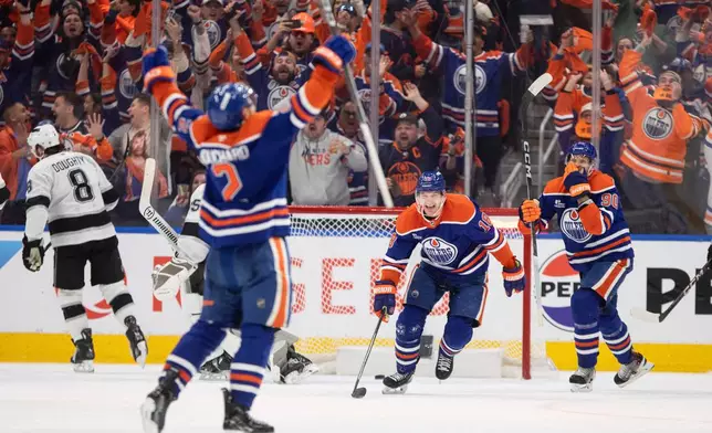 Edmonton Oilers' Evan Bouchard (2), Zach Hyman (18) and Corey Perry (90) celebrate a goal against the Los Angeles Kings during the third period of an NHL playoff game in Edmonton on Sunday, April 27, 2025. (Jason Franson/The Canadian Press via AP)